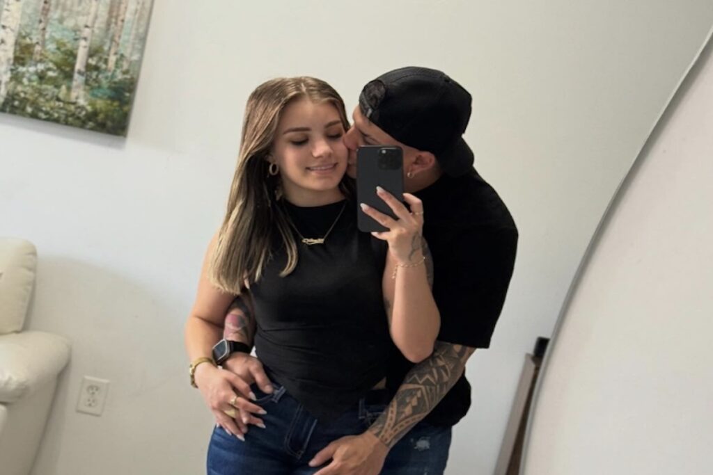 Pareja abrazada tomando selfie en espejo